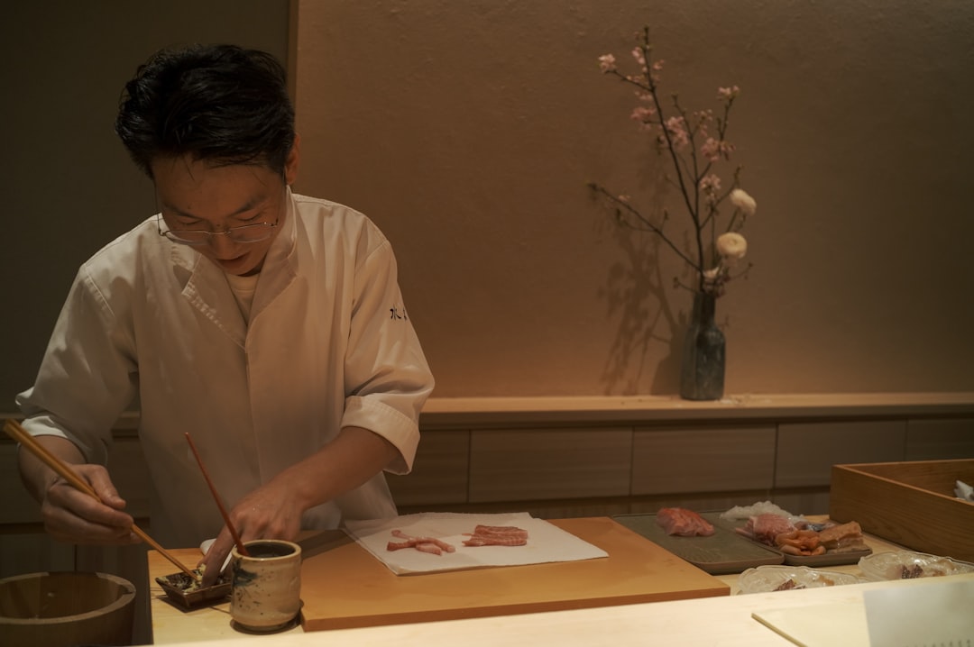 A ryokan staff member carefully folds yukata robes in preparation for guests arriving at a Kagurazaka ryokan
