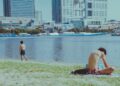 swimmer-in-tokyo-unsplash - TOKYOwebzine wading into the water at an open water swimming event near Tokyo Bay, with the city skyline visible in the background