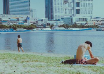 swimmer-in-tokyo-unsplash - TOKYOwebzine wading into the water at an open water swimming event near Tokyo Bay, with the city skyline visible in the background