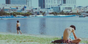 swimmer-in-tokyo-unsplash - TOKYOwebzine wading into the water at an open water swimming event near Tokyo Bay, with the city skyline visible in the background