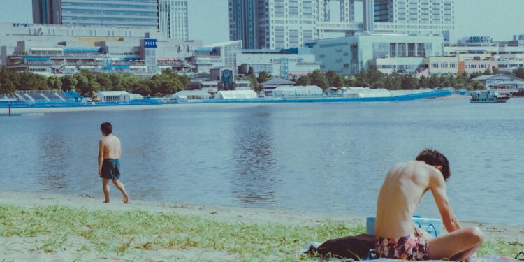 wading into the water at an open water swimming event near Tokyo Bay, with the city skyline visible in the background