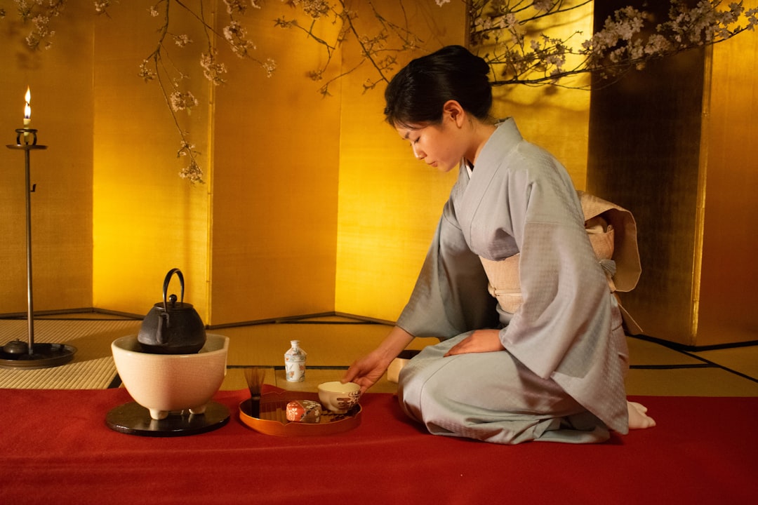 A guest relaxes with cold barley tea on a tatami mat inside a Kagurazaka ryokan during August's intense summer heat.