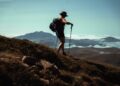 woman-hiking-mountain-dawn-unsplash - TOKYOwebzine A woman hiker pauses on the Yoshida Trail during Mt Fuji climbing season, with the early morning sky turning pink behind her.
