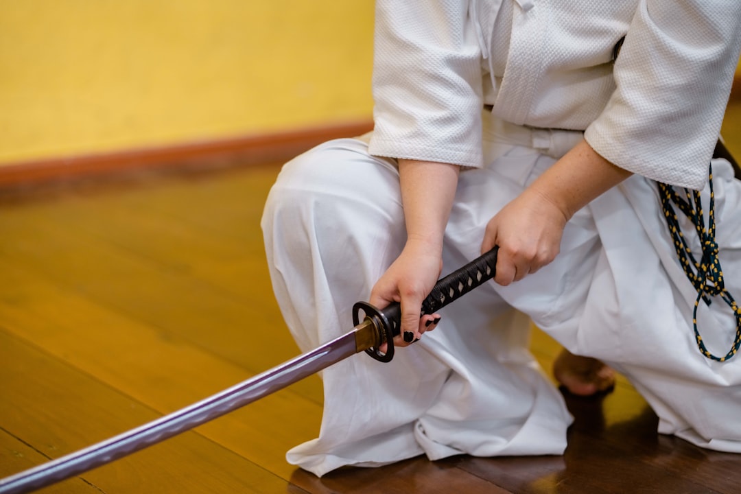 A woman in full kendo armor practices sword technique at a Tokyo dojo that teaches in English