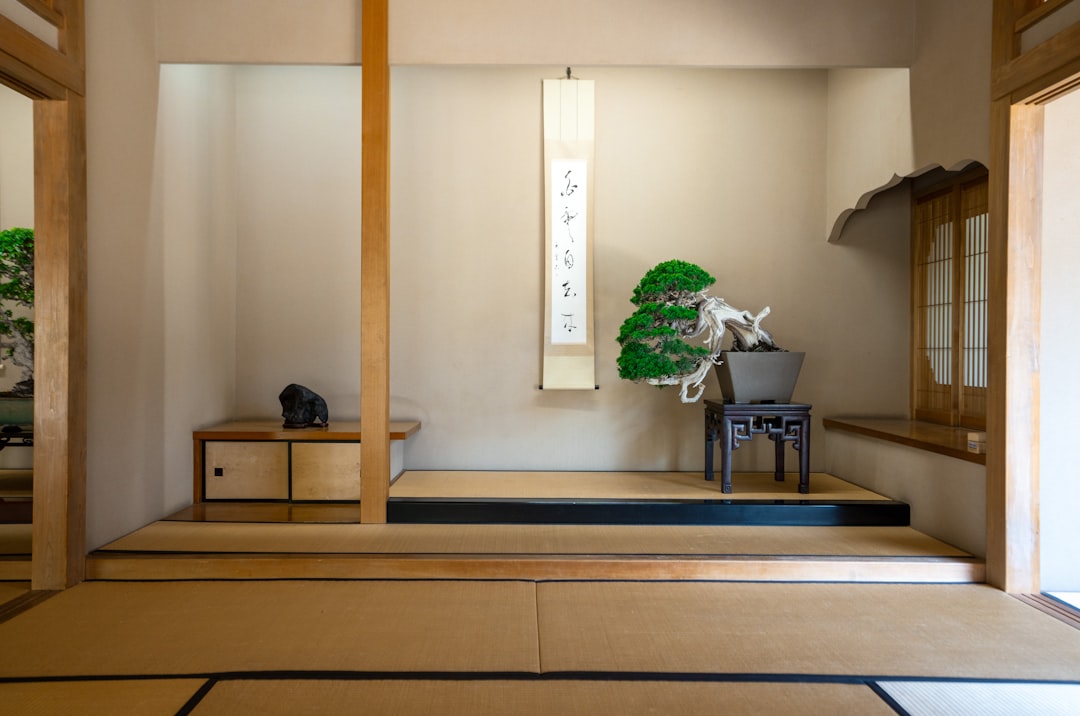 houseplant beside a window in her minimalist Tokyo apartment, practicing the daily ritual that keeps the space calm and alive