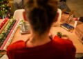 woman-wrapping-gift-japanese-cloth-unsplash - TOKYOwebzine A woman in Tokyo carefully practising furoshiki wrapping with a patterned square textile