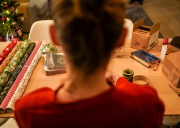 woman-wrapping-gift-japanese-cloth-unsplash - TOKYOwebzine A woman in Tokyo carefully practising furoshiki wrapping with a patterned square textile