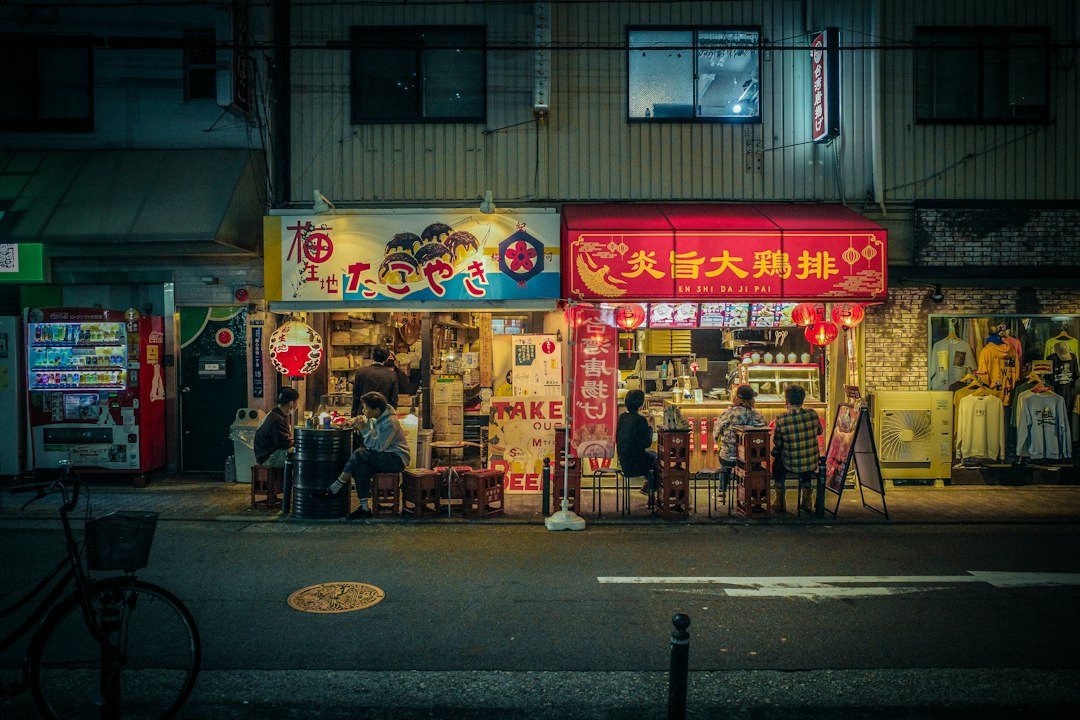 A tourist purchases street food from a vendor on a Tokyo shotengai investment street, and the dual local and tourism.