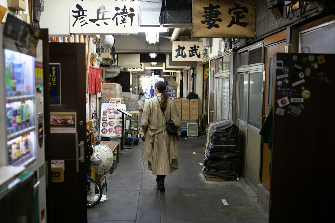 A woman browses goods at a stall on a shotengai investment street in a Tokyo residential neighborhood.
