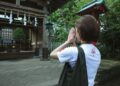 A woman cleans a family gravestone during autumn equinox week at a shitamachi temple in Tokyo