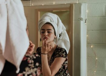 Woman treating dry skin with hydrating lotion in winter