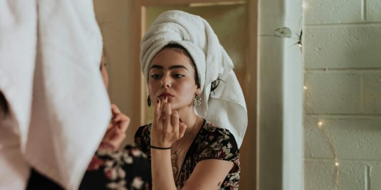 Woman treating dry skin with hydrating lotion in winter
