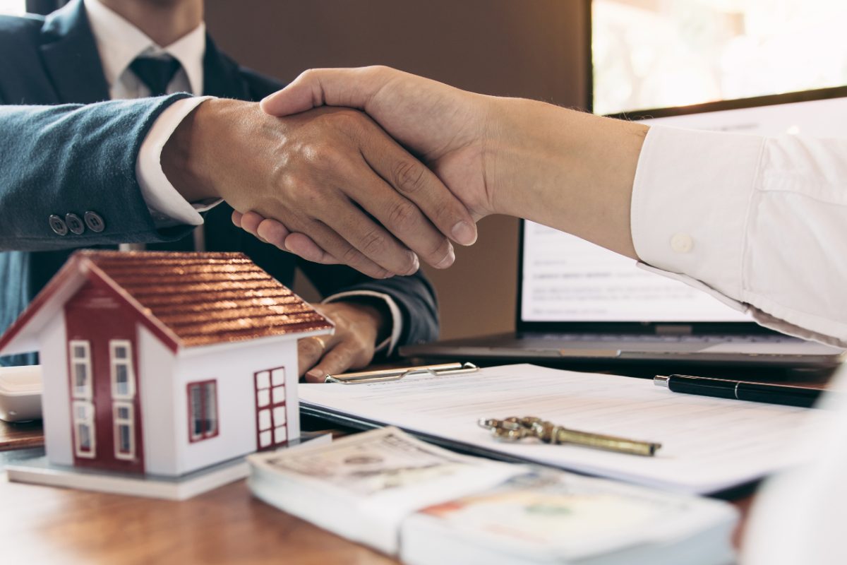 Um comprador de primeira viagem revisando dados de rendimento de aluguel para bairros de Tóquio com um agente imobiliário