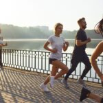 A group of runners at different paces gathering at a Tokyo running club meetup in Yoyogi Park at sunrise