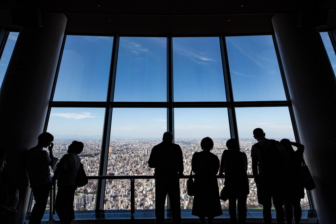 Un ejecutivo de negocios revisa documentos en una oficina central de Tokio, con un horizonte de la ciudad visible a través de la ventana.