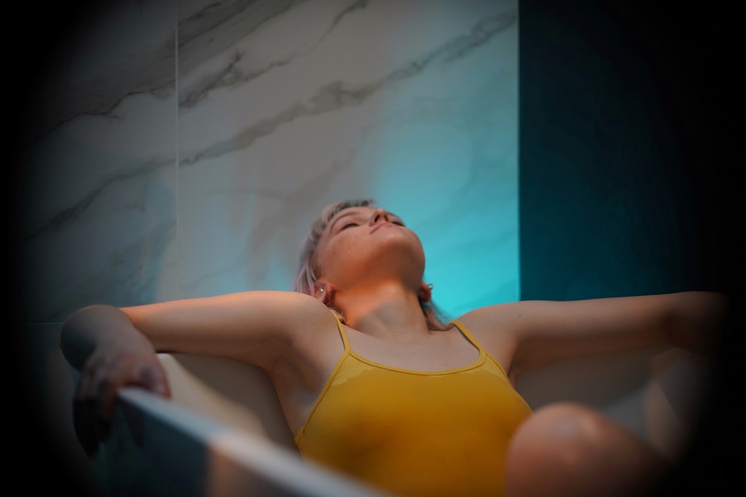 A woman in a float therapy pod at a Tokyo wellness studio, preparing for a session of sensory rest.