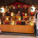 A kimono-dressed host welcomes arriving guests at a Kagurazaka ryokan entrance during the summer Obon season in Tokyo.