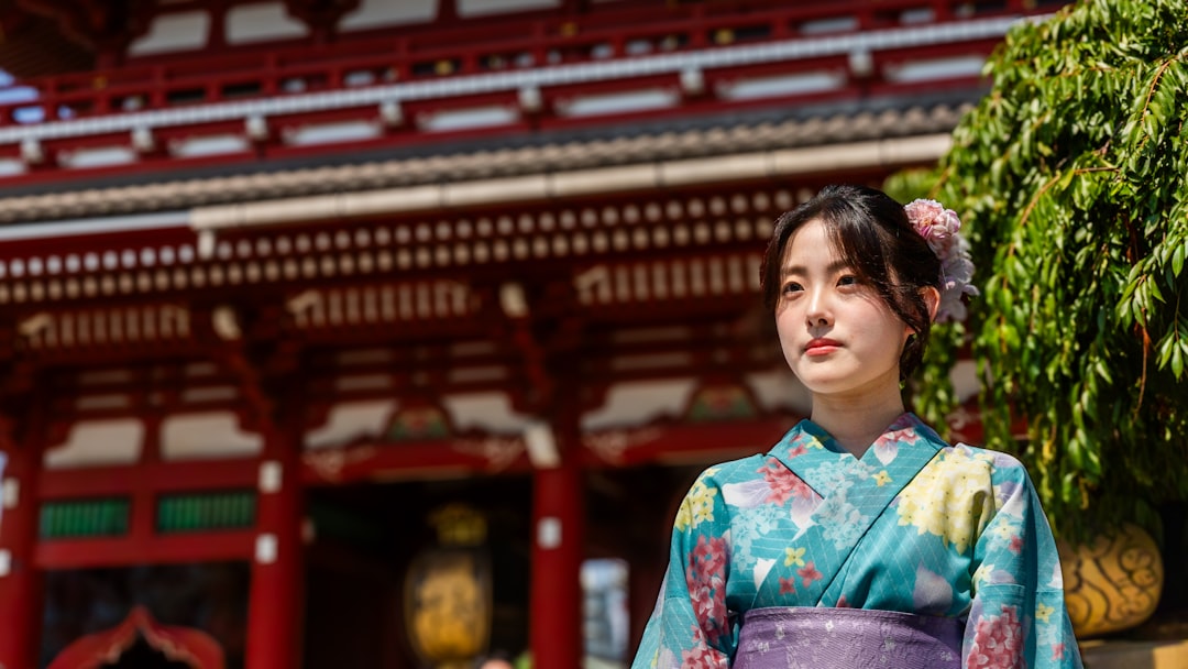 Un ospite in accappatoio yukata siede davanti a un tavolo da cena kaiseki di un ryokan di Tokyo preparato con piatti stagionali e lanterne di carta.