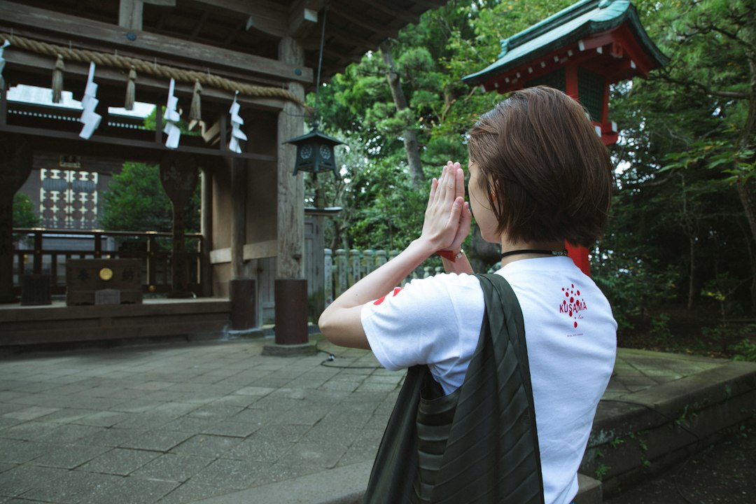 東京の下町の寺院にて、秋分の日の一週間に家族の墓石を掃除する女性